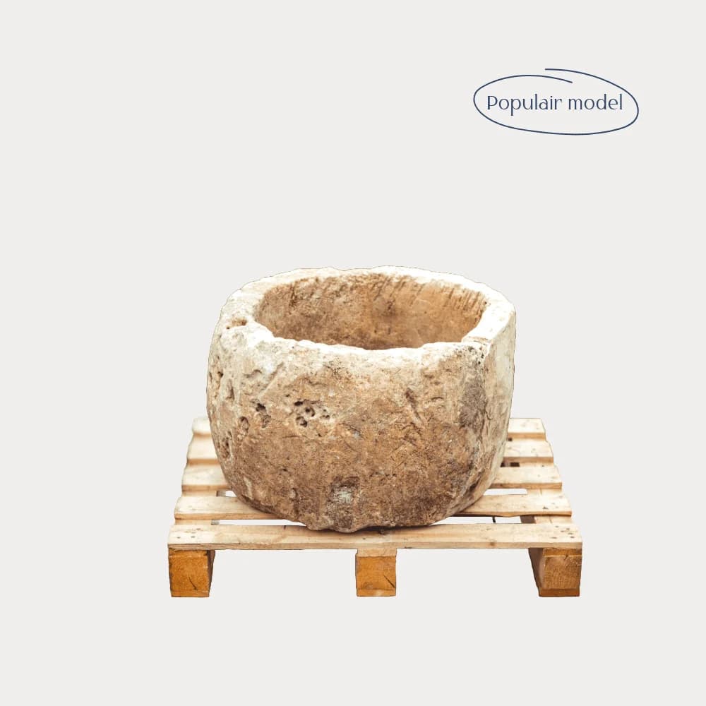 Beige natuurstenen pot met kuiltjes in het steen, laag model (37×63), handgemaakt en verweerd, persoonlijk ingekocht in Indonesië
